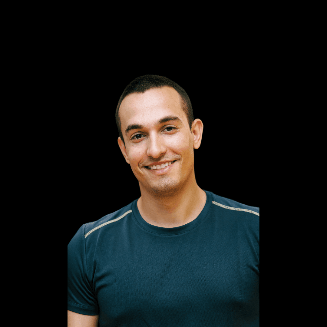 Smiling person wearing a dark t-shirt against a black background.